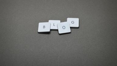 B, L, O & G keycaps of a keyword lying on a grey surface spelling out 'blog'