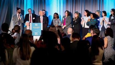 Judge David Tatel on stage surrounded by former law clerks