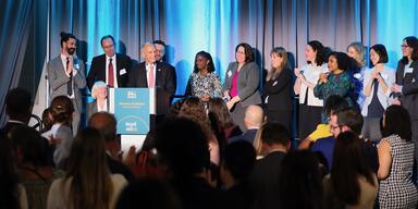 Judge David Tatel on stage surrounded by former law clerks