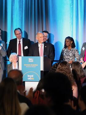 Judge David Tatel on stage surrounded by former law clerks