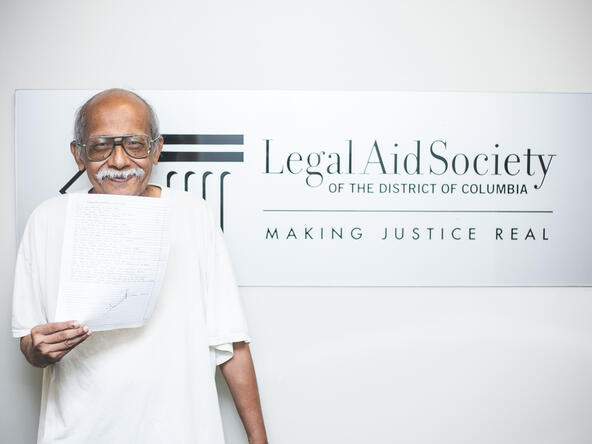 Housing client in front of the Legal Aid DC sign