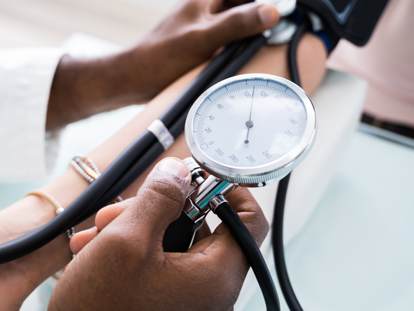 A doctor takes a patient's blood pressure