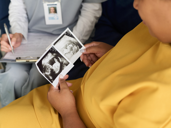 Pregnant woman looks at ultrasound images